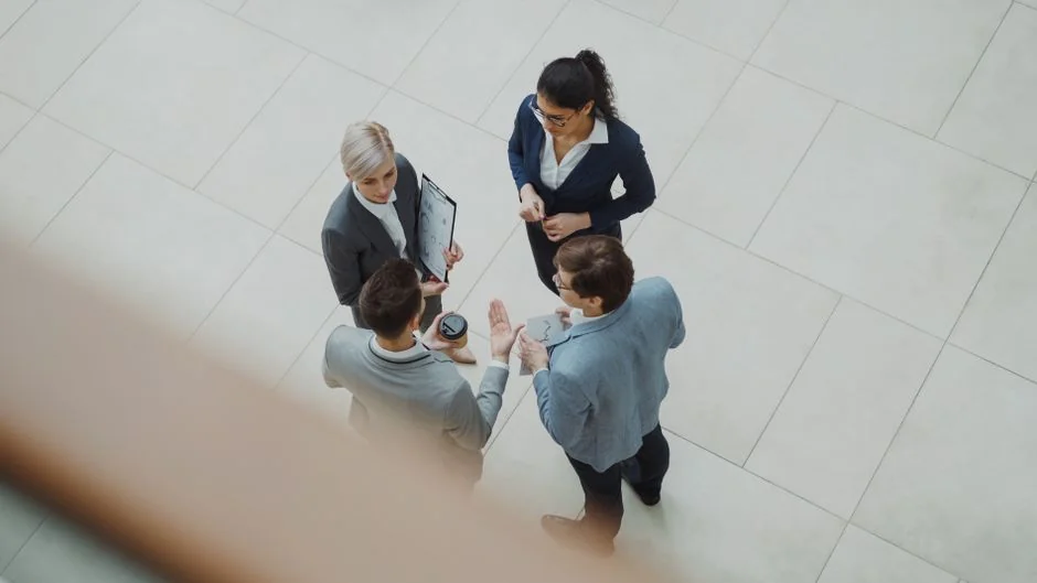 Personne utilisant un smartphone pour analyser le marché boursier depuis son bureau à domicile.